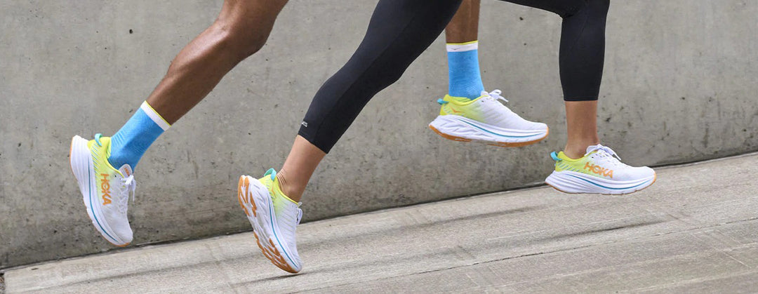 Man and woman running with white hoka shoes 